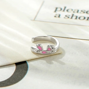 Cute silver rabbit ear cuff with pink enamel detail for women on textured background
