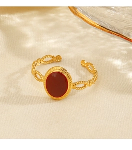 Macro detail of gold vintage open ring featuring a large red oval stone and chain band