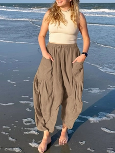 Detail of high waist khaki wide leg pants featuring elastic waist and large side pockets
