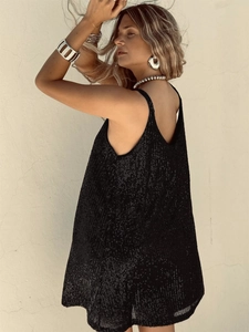 Détail d'une robe noire à paillettes avec un décolleté en V plongeant et un dos nu sexy