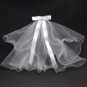 Detailed view of a white double-layer bridal veil with satin bow and curled edges