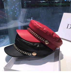 Detail of red and black PU leather sailor hats with gold metal chains and buttons