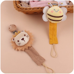Handmade beech wood pacifier clips with plush bee and lion designs on cotton linen straps