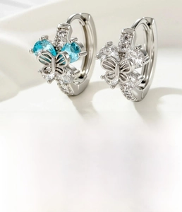 Détail macro de créoles papillon en cuivre argenté avec zircon bleu et diamètre de 10 mm