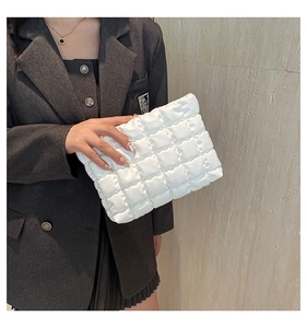 Gros plan d'une pochette nuage blanche matelassée au design minimaliste plissé