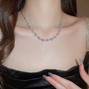 Close-up of a silver zircon square pendant necklace worn on a model neckline