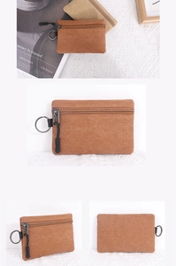 Detail view of canvas coin purse showing sturdy zipper and metal keychain clip attachment