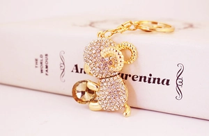 Macro detail of golden sheep keychain featuring clear rhinestones and champagne crystal