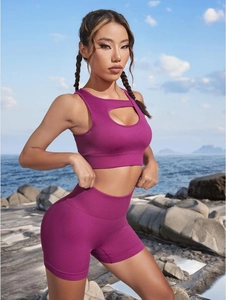 Detail of deep magenta ribbed seamless yoga set featuring chest cutout in outdoor setting