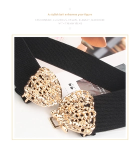 Detail view of a black elastic waist belt with a golden butterfly filigree metal buckle