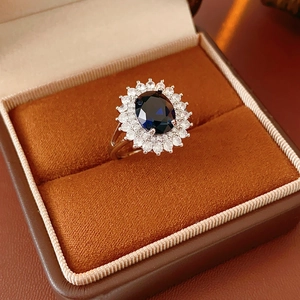 Macro detail of royal blue oval gemstone ring with double halo diamonds in a velvet box