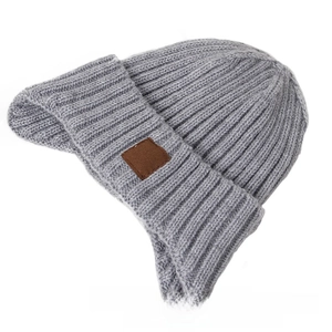 Detail of grey knitted winter hat showing ear flaps and decorative brown leather label