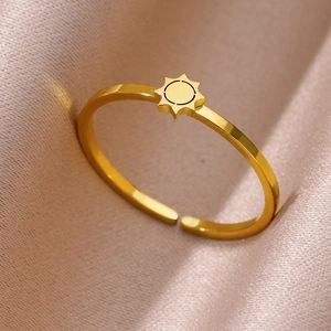 Detailed view of gold sun pattern open ring on soft silk fabric background