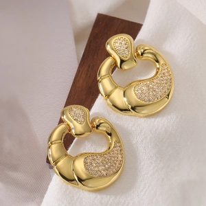 Elegant gold plated C-shaped earrings with sparkling cubic zirconia on white fabric