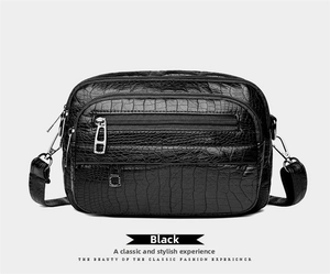 Vue détaillée du sac bandoulière noir texture crocodile avec des poches zippées