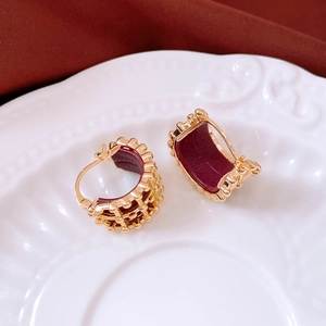 Detailed macro of 18K gold-plated lattice earring with burgundy leather interior texture