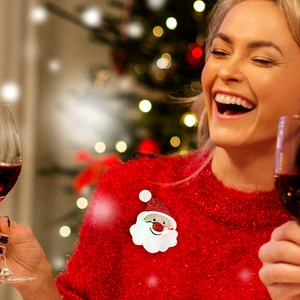Smiling woman wearing a glowing Santa Claus brooch at a festive Christmas party