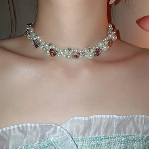 Close-up of pearl choker necklace featuring pink and purple heart crystals and rhinestones