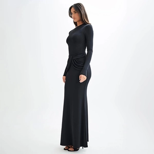 Détail d'une robe longue noire à manches longues avec nœud à la taille et fronces