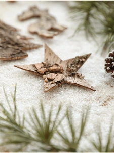 Macro detail of natural bark Christmas ornaments featuring star and horse wood carvings