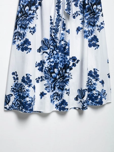 Gros plan sur l'imprimé floral bleu et papillon élégant sur le tissu satiné blanc