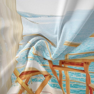 Detail shot of smooth polyester fabric showing a tropical beach print and soft draping texture