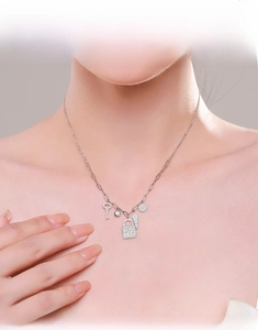 Close-up of S925 silver necklace with key and lock charms on elegant model neck