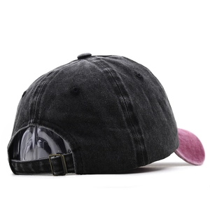 Detail of adjustable brass buckle and washed cotton fabric on dark grey baseball cap