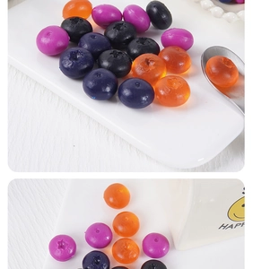Detail bunter Harz-Blaubeeren auf weißem Teller für DIY-Bastelarbeiten und Deko