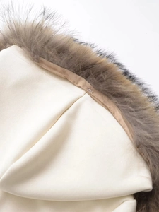 Detail of detachable real fur collar with button fastening on cream hoodie coat