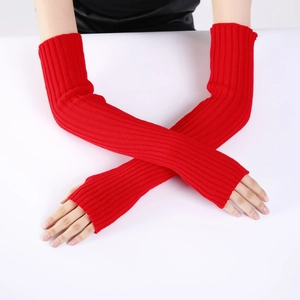 Close-up of red knitted arm warmers with vertical stripe texture on a model