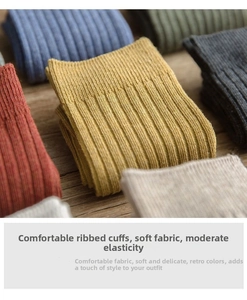 Detail of ribbed knit crew socks in retro tones on a wooden surface for autumn winter