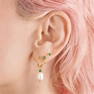 Macro shot of S925 silver paperclip earrings with emerald gems and teardrop pearls