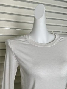 Detail of the crew neck and shoulder seams on a white slim-fit wool t-shirt