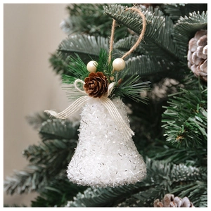 Cloche de Noël blanche pailletée avec pommes de pin et aiguilles sur branche de sapin