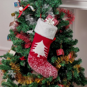 Detail eines roten Strick-Weihnachtssocken mit weißem Pelzrand am Weihnachtsbaum