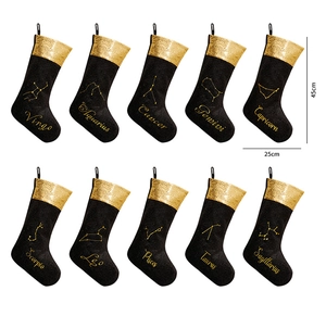 Detailed view of ten black velvet zodiac Christmas stockings with gold sequin cuffs