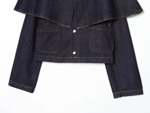 Detail of dark blue denim jacket featuring orange stitching and metal buttons