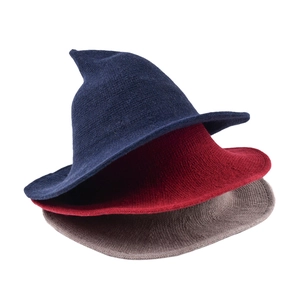 Detailed close-up of knitted witch hats in navy, red and grey with pointed tops