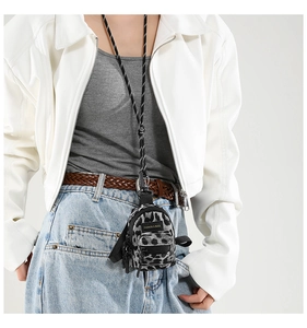 Close-up of leopard print mini crossbody bag on model with black strap and silver buckle