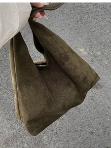 Close-up of olive green frosted suede bucket bag with geometric folding detail