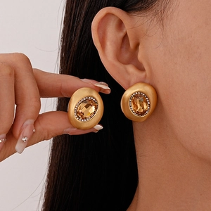 Vintage-Ohrstecker aus mattem Gold mit champagnerfarbenen Kristallen am Ohr getragen