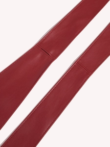 Detailed macro view of dark red leather belt with precise stitching and refined texture