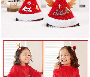 Detail of Christmas hair clips with red hats, antlers, and Merry Christmas text