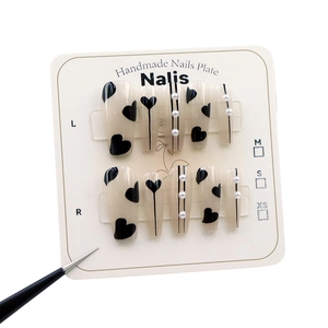 Faux ongles faits main avec motifs de cœurs noirs et perles en forme de trapèze long