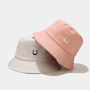 Minimalist cotton bucket hat with embroidered smiley face in beige and peach pink colors