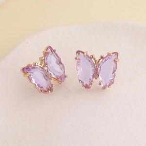 Macro shot of purple butterfly earrings with gold plating and cubic zirconia detail