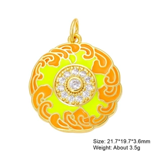 Macro shot of gold circular pendant with orange enamel and cubic zirconia stones