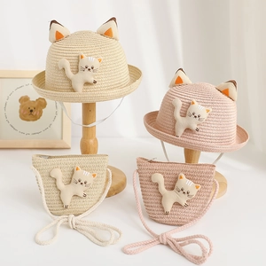 Close-up of kids straw sun hat and matching crossbody bag with cute 3D cat ear detail