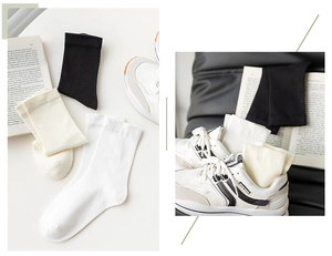 Detailed flat lay of black, white, and beige cotton socks paired with casual sneakers